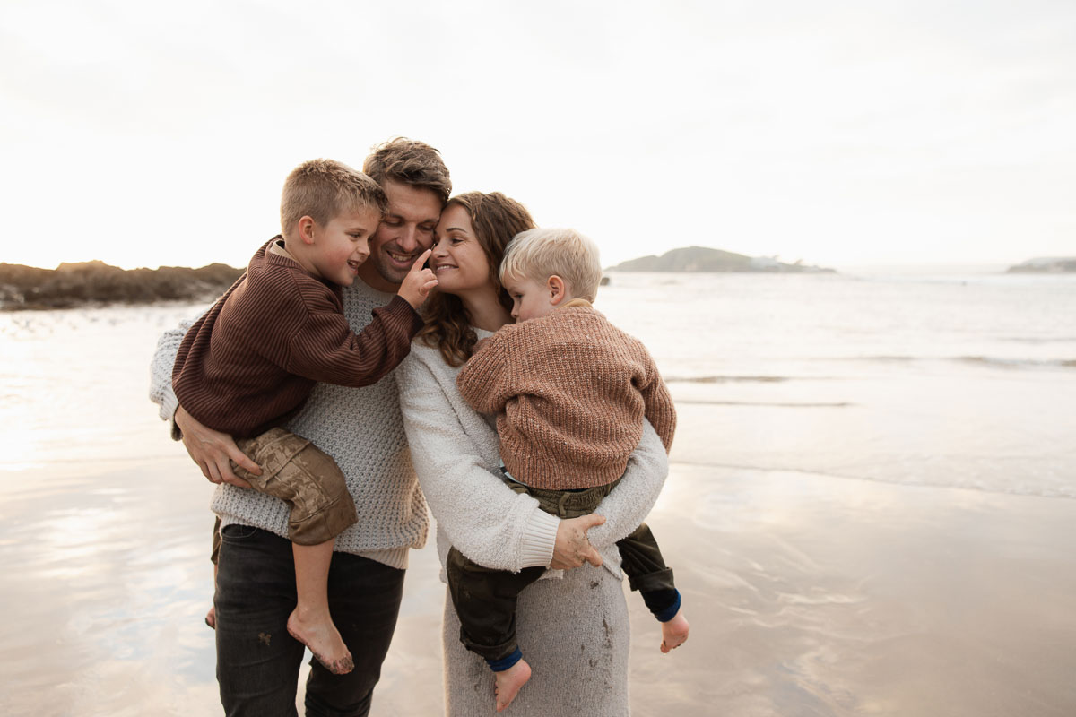 Family portrait with two children cuddling on Bantham Beach